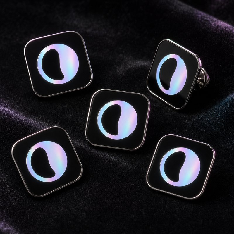 Enamel pins with the holographic logomark on black
